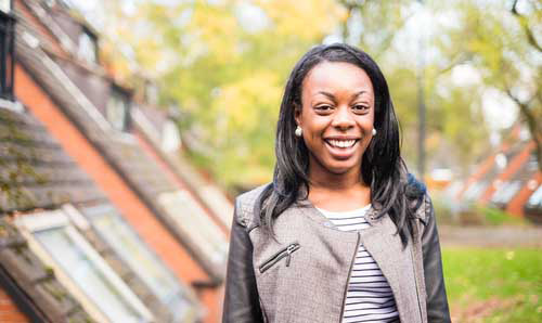 Smiling student next to a university building